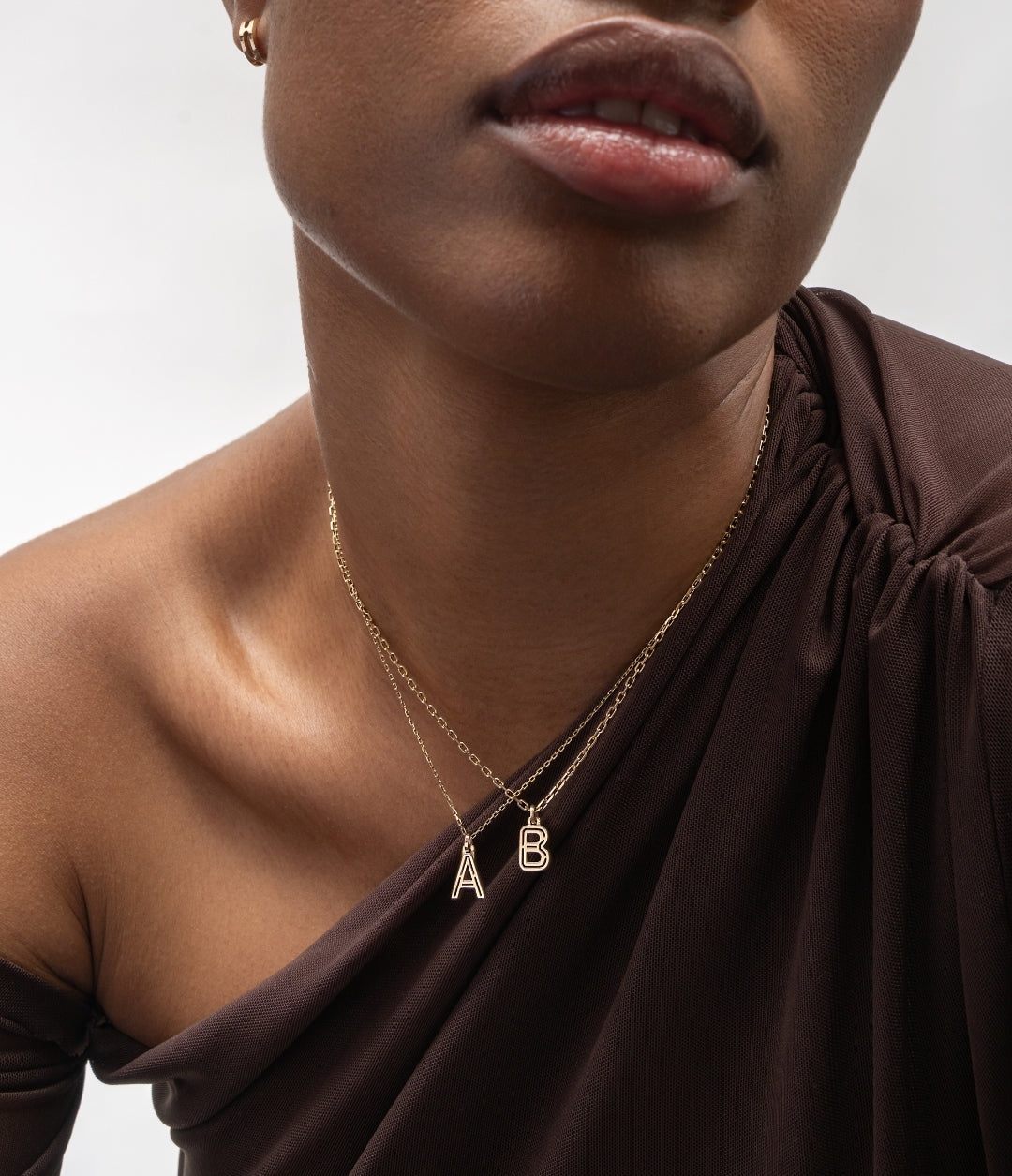 Woman wearing floral earrings and rings in yellow, rose, and green gold