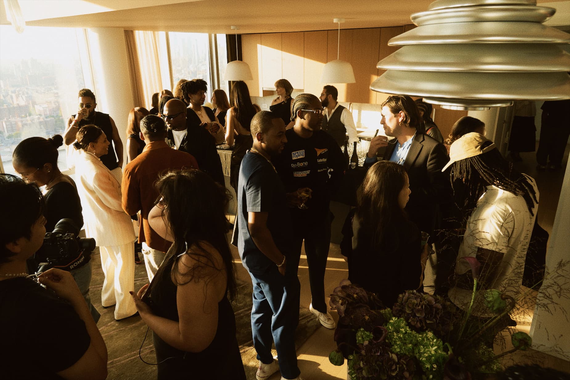 Group of people gathered in a modern indoor setting with large windows.