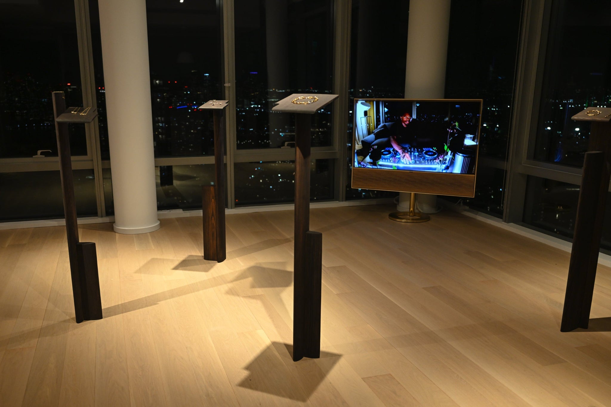 Audio equipment on stands in a room with large windows at night