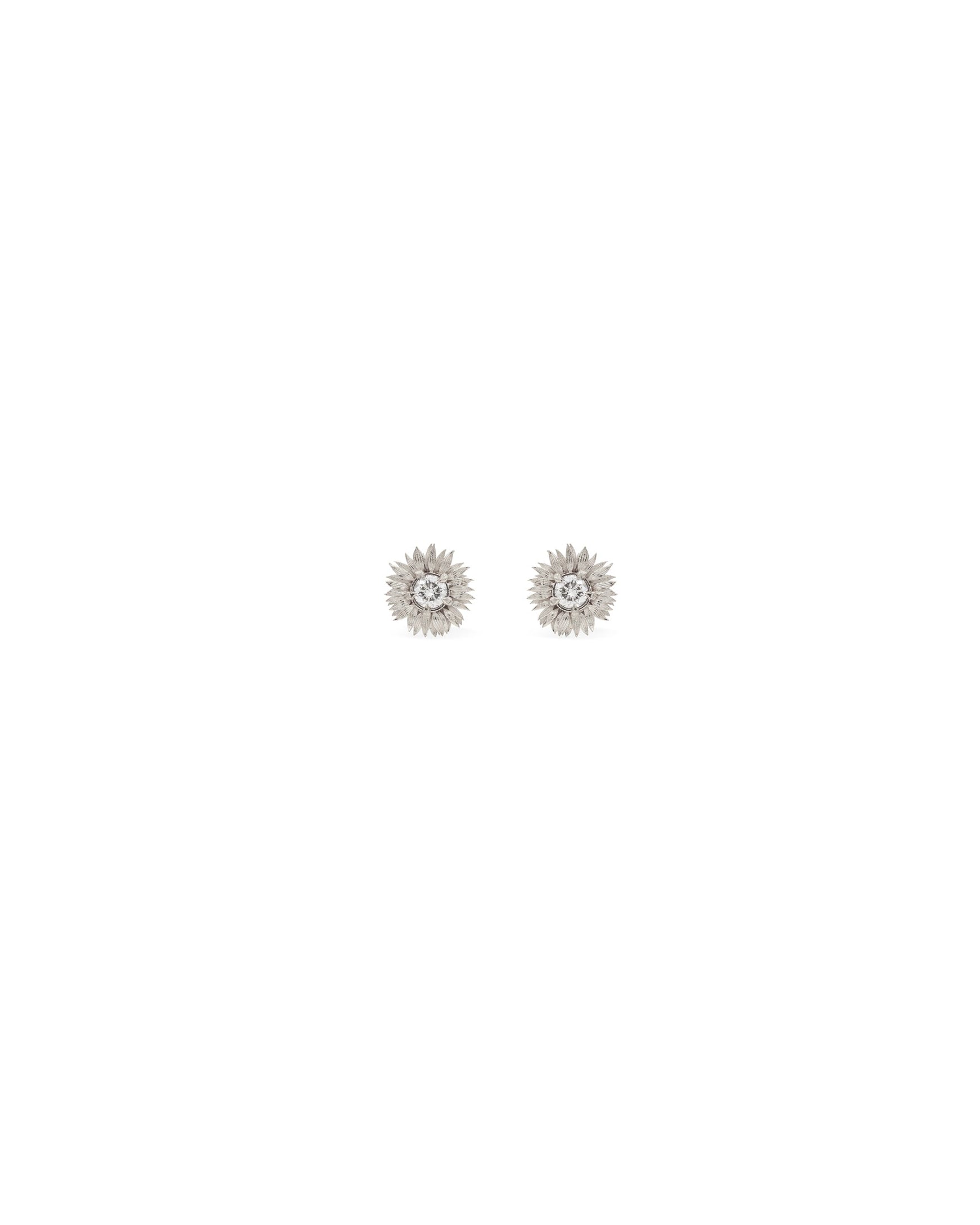 A pair of 14k white gold sunflower earrings with white diamonds at the center, presented against a white background.