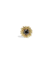 Gold flower-shaped earring with a central black gemstone on a white background