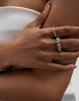 Woman wearing two sterling silver rings, one being a branch like ring the other one a flower ring