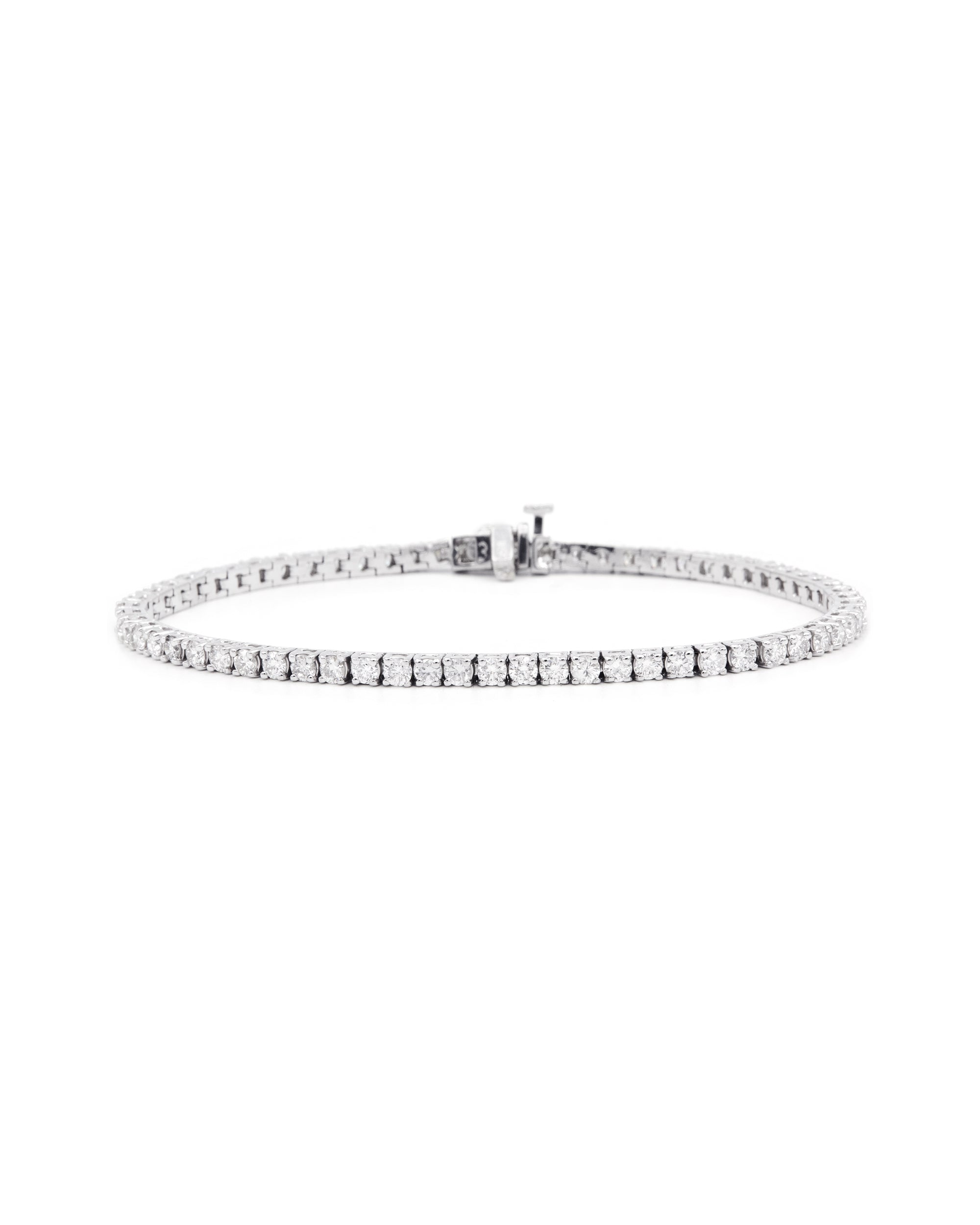 A white gold tennis bracelet featuring a series of round diamond charms, with a clasp fastening.
