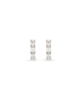 Small white gold diamond hoops with emerald cut white diamonds on a white background