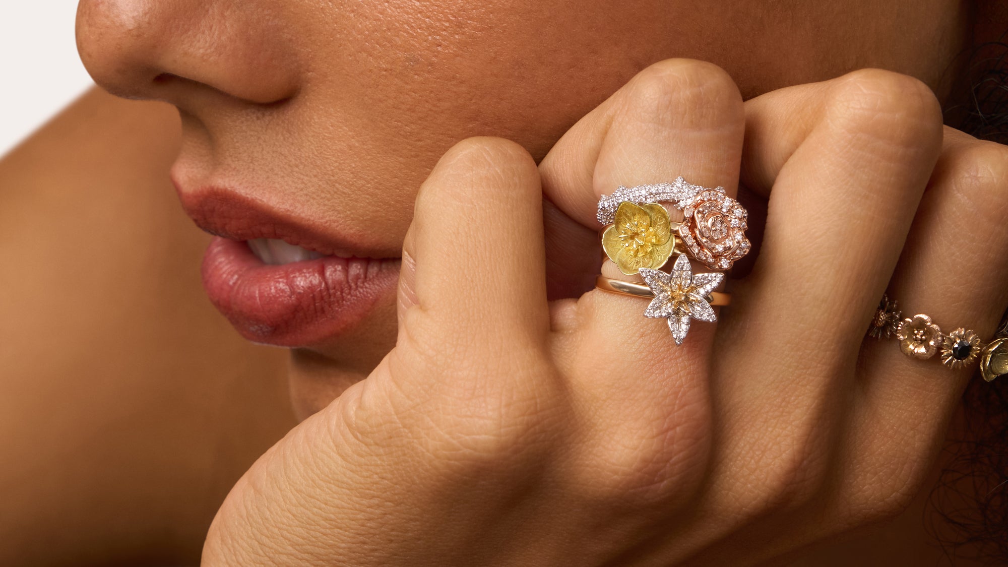 Close-up of a woman's hand wearing a diamond ring with a yellow gemstone.