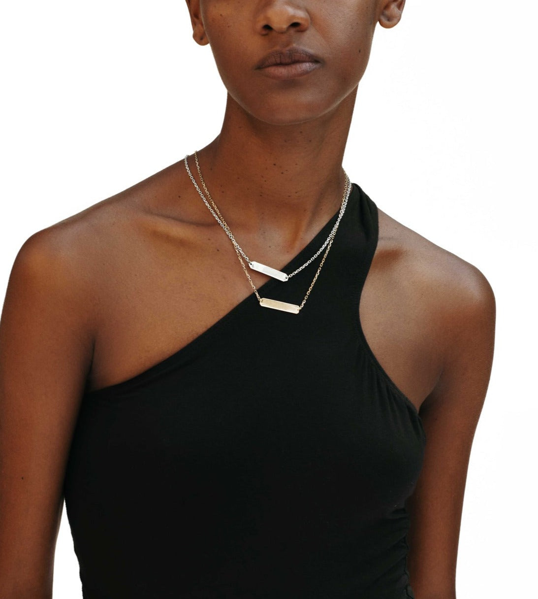 The Bernard James Signa necklace features a radiant hand-cut ID plaque on a sterling silver diamond cut cable chain,  connected with 14k gold jump rings. The plate is kept clean on the front for a sleek feel but can be engraved upon request.